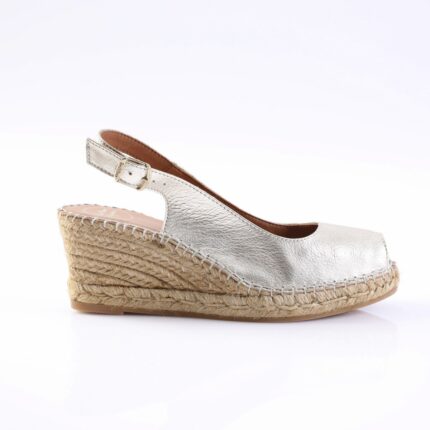 Silver metallic wedge sandal with an ankle strap and buckle on a braided jute espadrille heel