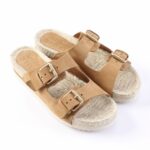 Tan leather sandals with two adjustable buckles and a textured, rope-like footbed for a casual summer look.