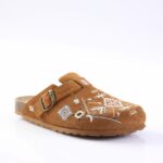 Brown suede clog/slipper with an adjustable strap and decorative blue and white embroidery on the toe area.