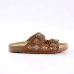 Brown suede sandal with two adjustable buckled straps, embroidered geometric designs, and a cork footbed.