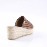 Brown woven espadrille slide with a braided jute platform heel, viewed from the back-right side, showing textured upper and rope sole.