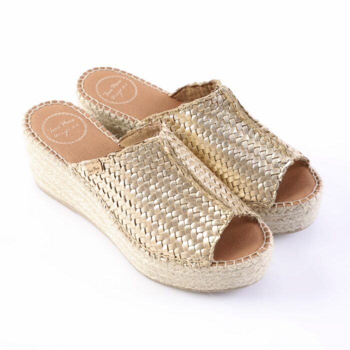 Gold woven espadrille wedge sandals with open toes and thick rope sole on a white background