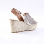 Metallic silver wedge espadrille with an ankle strap and braided jute sole.