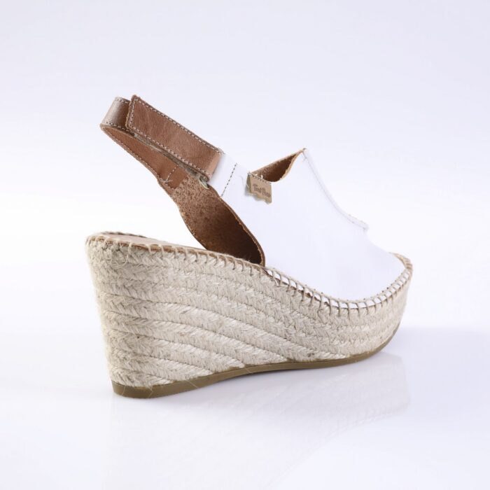 White espadrille wedge sandal with a brown leather ankle strap and braided jute platform.