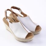 White open-toe wedge espadrille sandals with a braided jute sole and ankle strap on a white background.