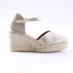 Silver metallic espadrille wedge sandal with ankle strap and woven jute sole.