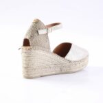 Beige espadrille wedge sandal with a braided rope sole and ankle strap.