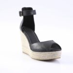 Black open-toe ankle-strap wedge sandal with a braided rope espadrille sole and buckle strap.