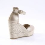 Champagne metallic wedge sandal with ankle strap and braided jute sole photographed from the back-left side.