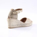Beige woven espadrille wedge sandal with ankle strap and buckle on a white background.