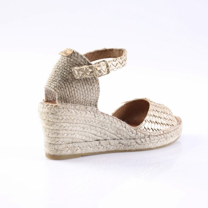Beige woven espadrille wedge sandal with ankle strap and buckle on a white background.