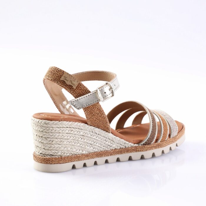 Women's wedge espadrille sandal with braided rope heel and metallic silver straps, tan ankle strap with buckle.