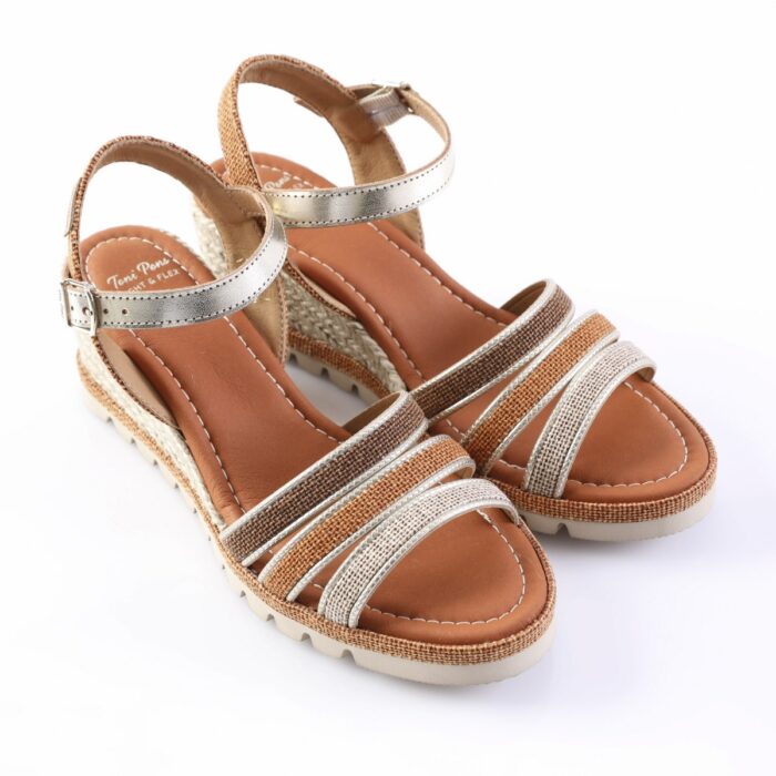 Pair of women’s strappy wedge sandals with metallic silver straps and tan footbeds on a white background.
